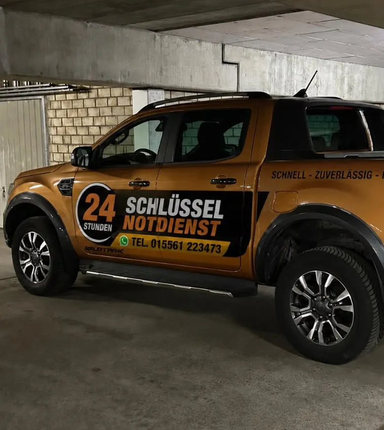 Der orange Ford Ranger von Voulgaris mit der Aufschrift 24 Stunden Schlüssel Notdienst in einer Tiefgarage