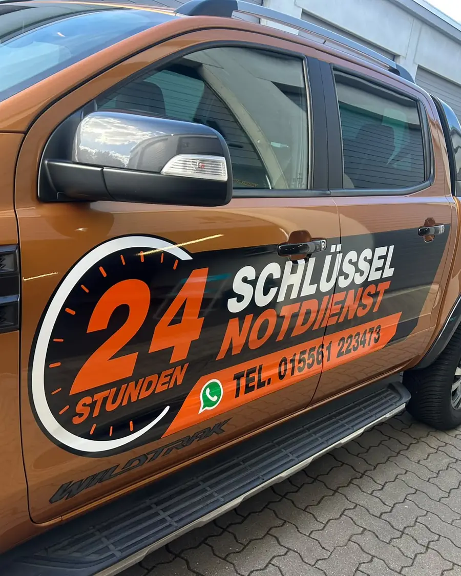 Fahrertür des Einsatzfahrzeugs mit 24-Stunden-Zifferblatt und Telefonnummer